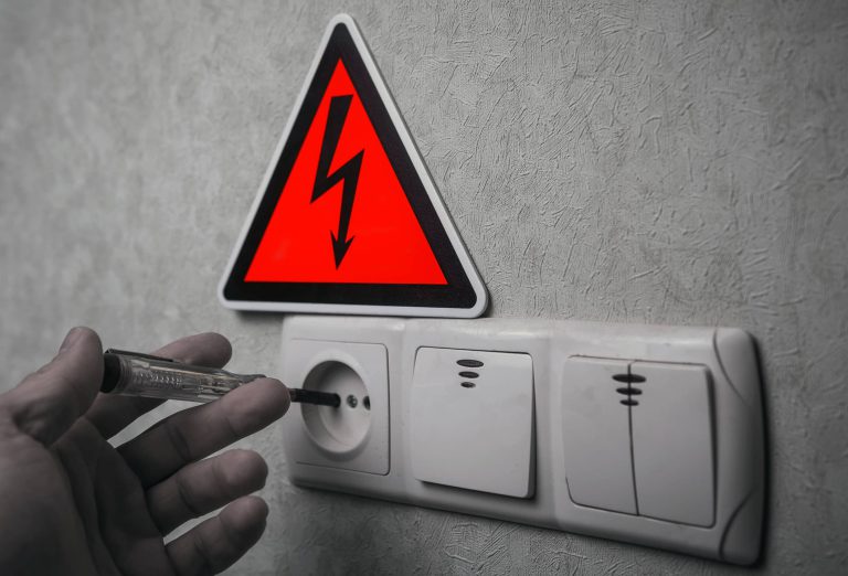 Elektryk dokonuje pomiarów elektrycznych aby nie było porażenia prądem