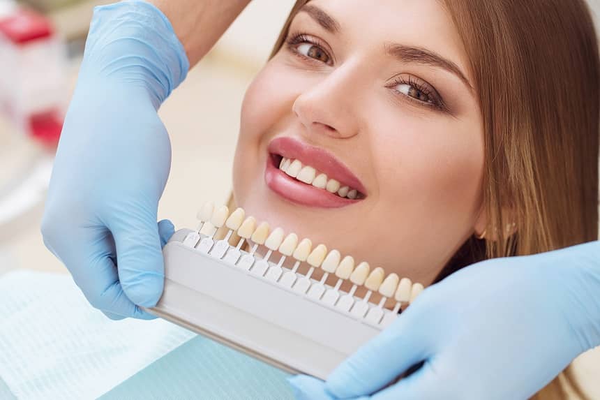 kobieta u stomatologa dobiera odcień implantów