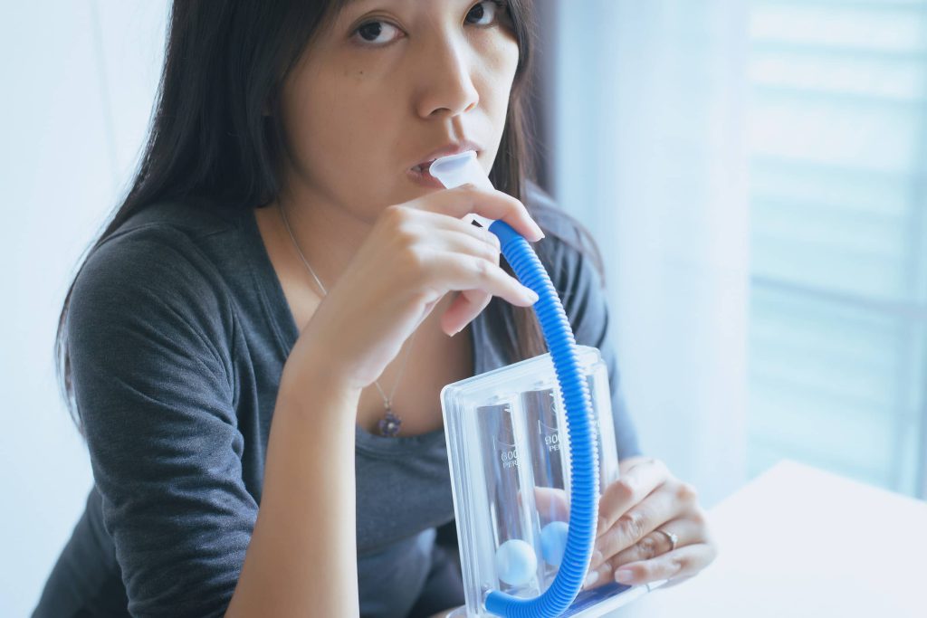 kobieta używa spirometru motywacyjnego